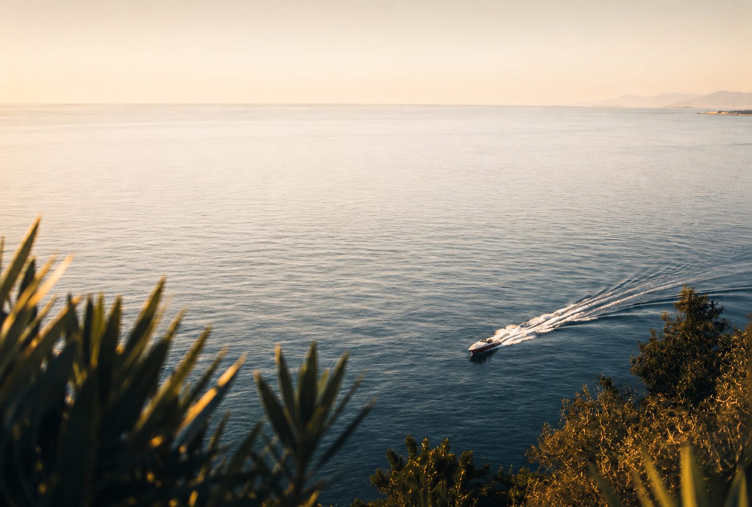 Sunset over the Greek coast with a boat